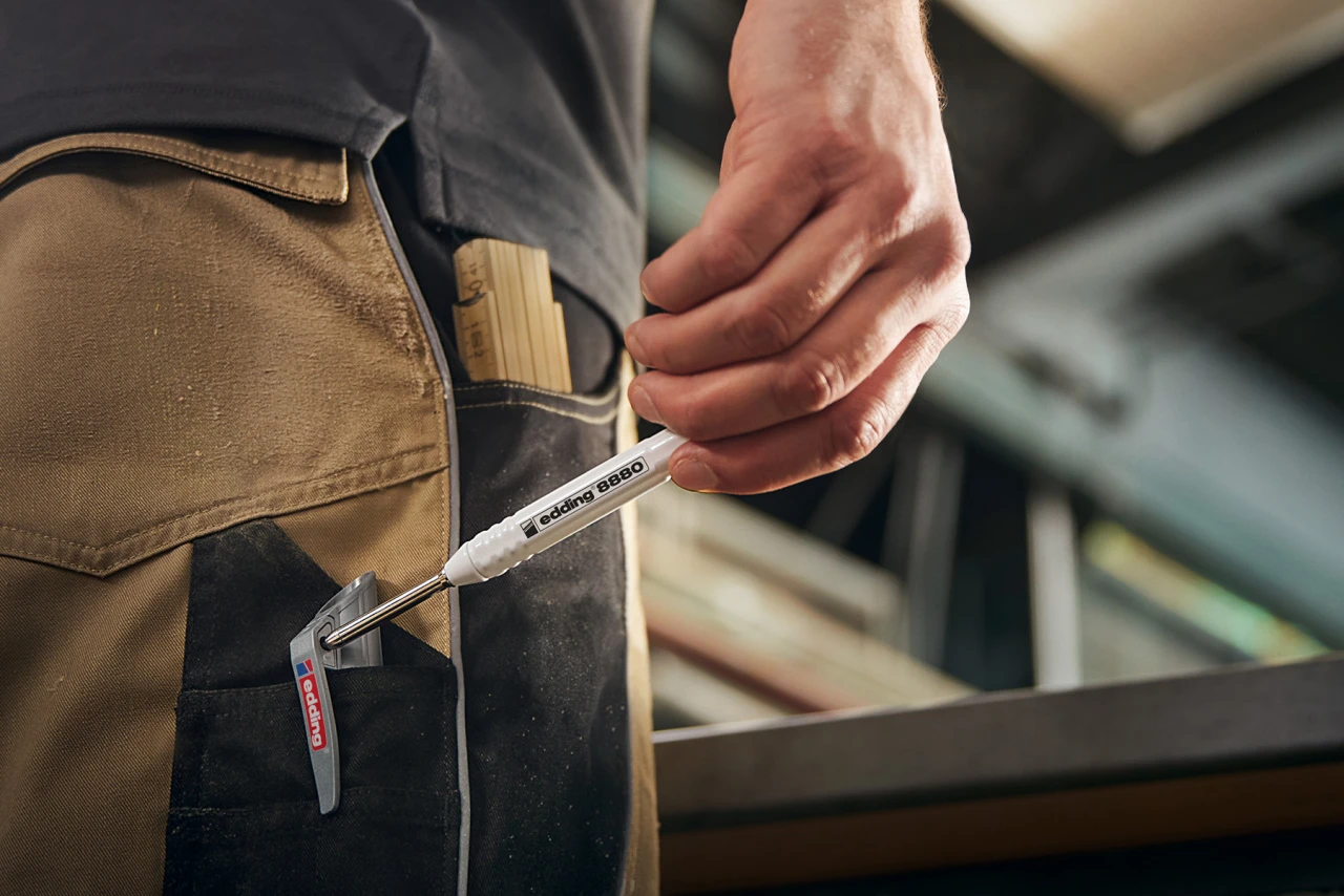 Foto eines Eddings. Dieser ist an der Hosentasche einer Handwerkerhose befestigt.