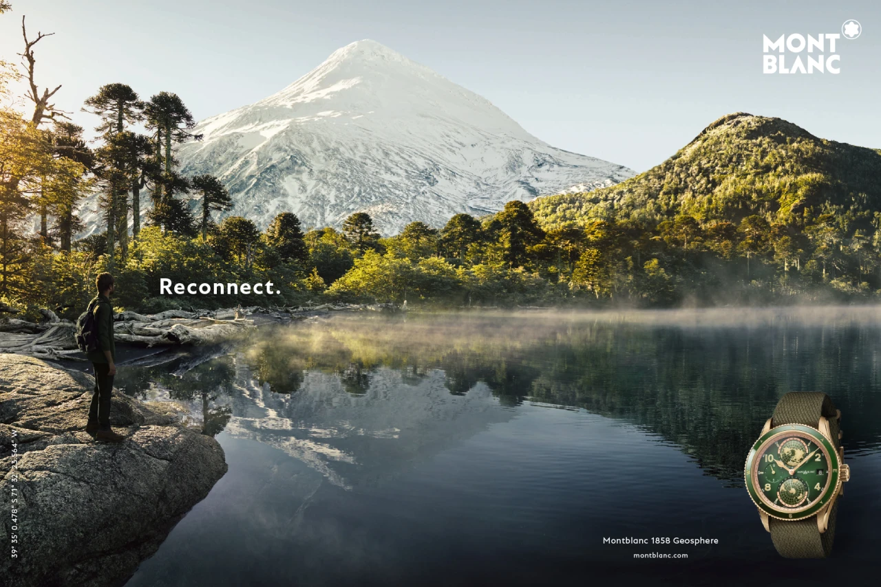 Mit Reconnect präsentierte Montblanc sein Universum - bestehend aus Abenteuer, Tradition, Leidenschaft und Qualität. CGI Rendering einer Montblanc Anzeige. Ein See mit grüner Landschaft im Hintergrund, rechts unten ist eine Montblanc Uhr zu sehen. Links steht eine Person und der Schriftzug "Reconnect""
