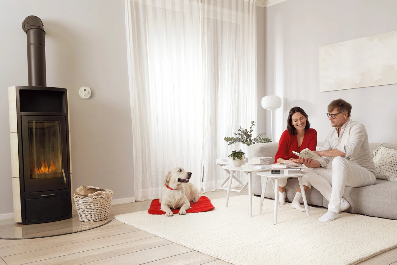 Albert Bauer übernahm die gesamte Organisation rund um Location, Produktion und Bookings. Wohnzimmer in welchem ein Mann und eine Frau auf einem Sofa sitzen, sie lesen ein Buch, ein Hund liegt auf dem Teppich